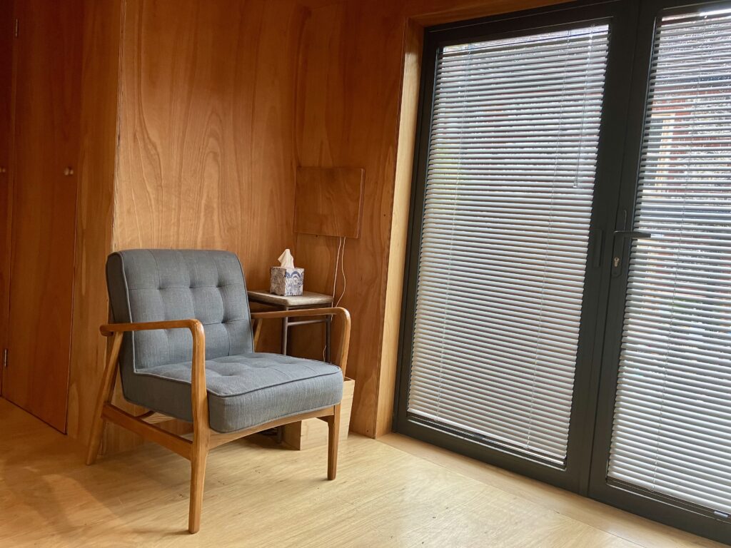 A comfortable chair in a modern, minimalist psychotherapy consultation room, designed for relaxation and privacy, located in Canterbury.
